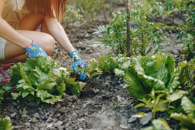 La bella donna lavora in un giardino