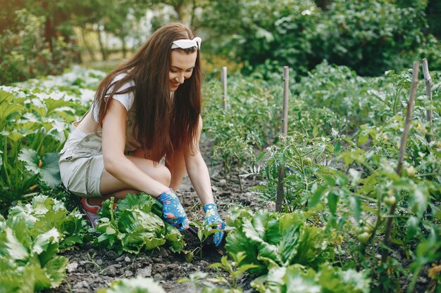 La bella donna lavora in un giardino