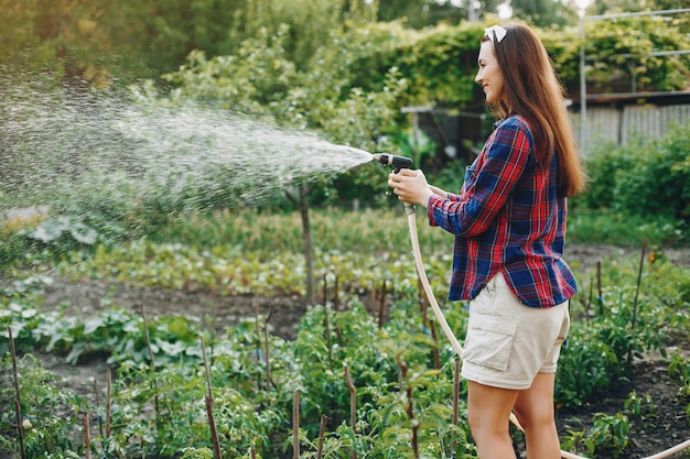 La bella donna lavora in un giardino