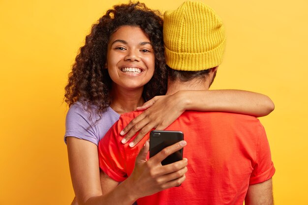 La bella donna premurosa ha i capelli lisci, abbraccia l'uomo con amore, si incontra dopo la partenza