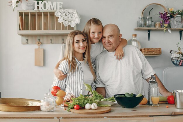 La bella famiglia prepara il cibo in una cucina