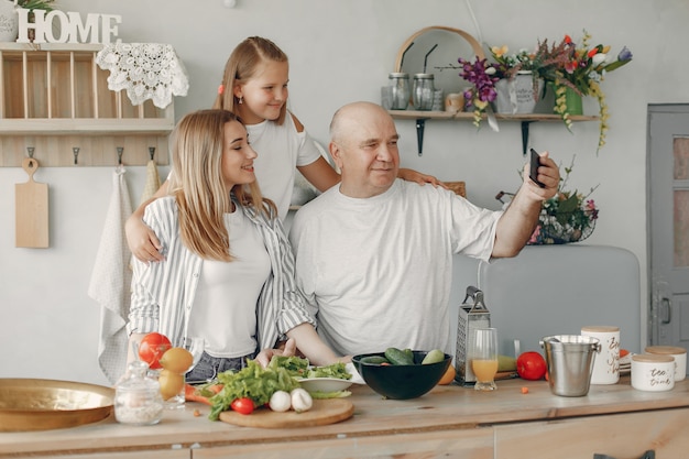 La bella famiglia prepara il cibo in una cucina