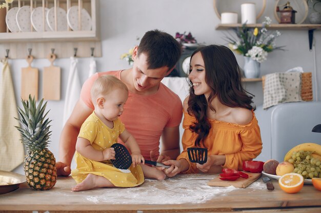 La bella famiglia prepara il cibo in una cucina