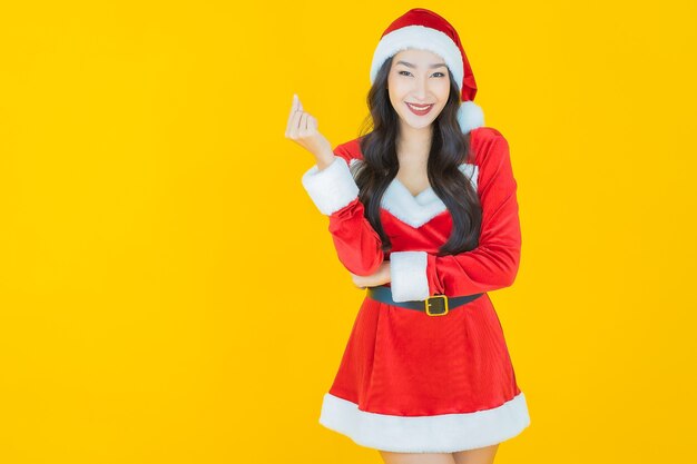 La bella giovane donna asiatica del ritratto indossa il costume di natale con l'azione su yellow