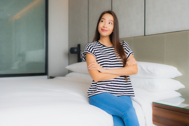 La bella giovane donna asiatica del ritratto si rilassa il sorriso felice in camera da letto