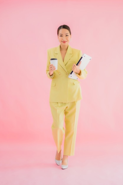 La bella giovane donna asiatica di affari del ritratto usa il computer portatile del computer sul colore