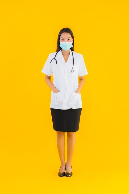 La bella giovane donna asiatica di medico del ritratto con la maschera per protegge covid19