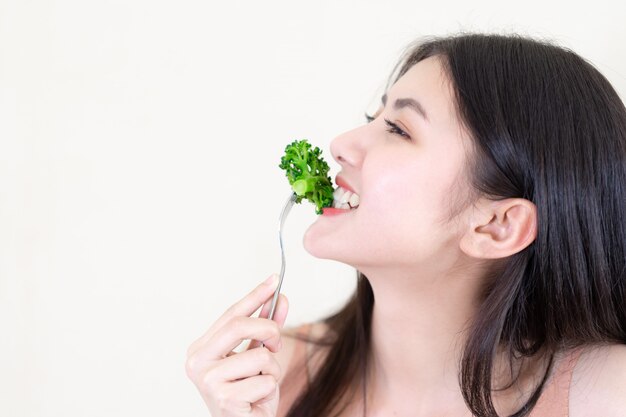 La bella ragazza asiatica di bellezza della ragazza di tatto felice mangia l&#39;insalata fresca dell&#39;alimento di dieta per buona salute di mattina