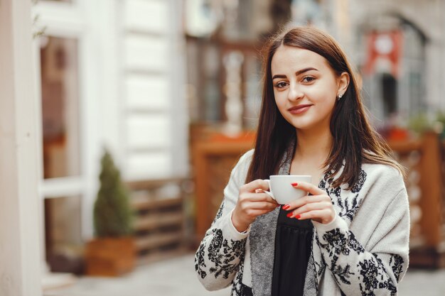 La bella ragazza beve il caffè