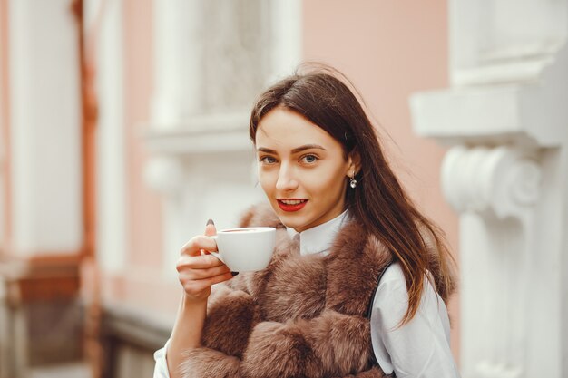 La bella ragazza beve il caffè