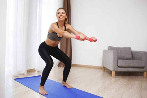 La bella ragazza di forma fisica fa gli esercizi di sport