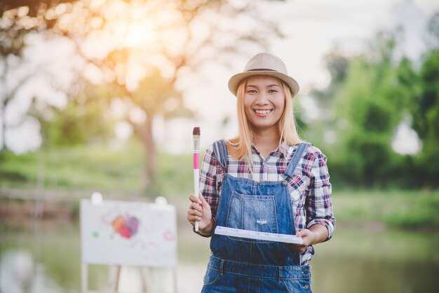 La bella ragazza disegna un&#39;immagine nel parco