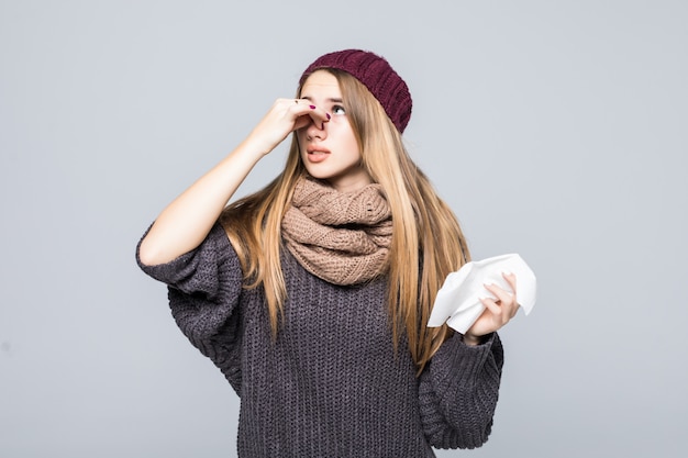 La bella ragazza in maglione grigio aveva mal di testa da influenza fredda su grigio