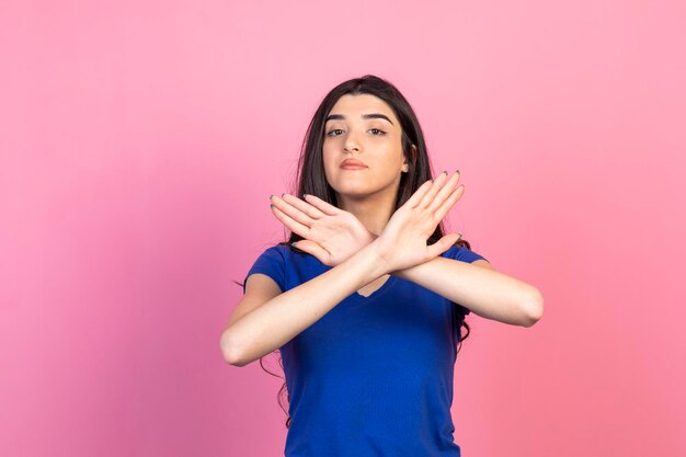 La bella ragazza incrocia le mani e fa il gesto n