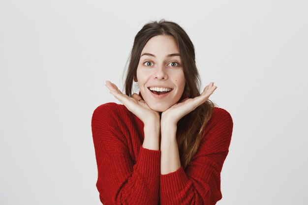 La bella ragazza si appoggia sulle mani, mostrando la pelle pulita