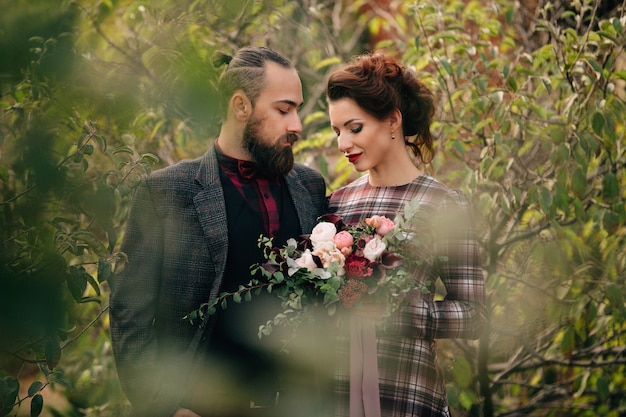 La bella sposa e lo sposo camminano nel giardino dopo la cerimonia di nozze