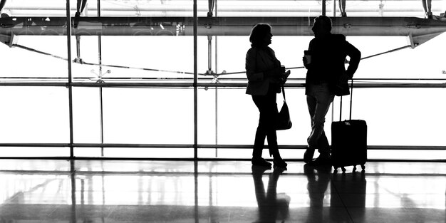 La coppia caucasica sta parlando insieme all&#39;aeroporto