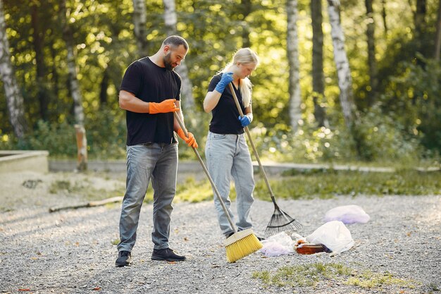 La coppia raccoglie l'immondizia nei sacchetti di immondizia in parco