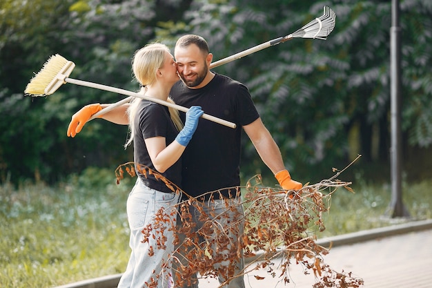 La coppia raccoglie le foglie e pulisce il parco