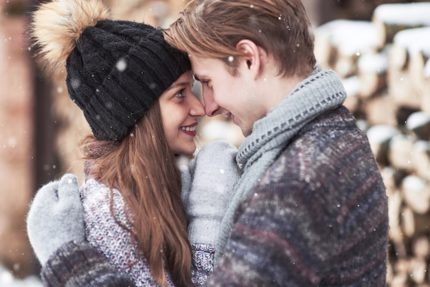 La coppia si diverte e ride. bacio. Giovani coppie dei pantaloni a vita bassa che si abbracciano nel parco di inverno.