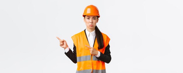 La costruzione di edifici e il concetto industriale sconvolgono l'ingegnere femminile imbronciato in abiti riflettenti
