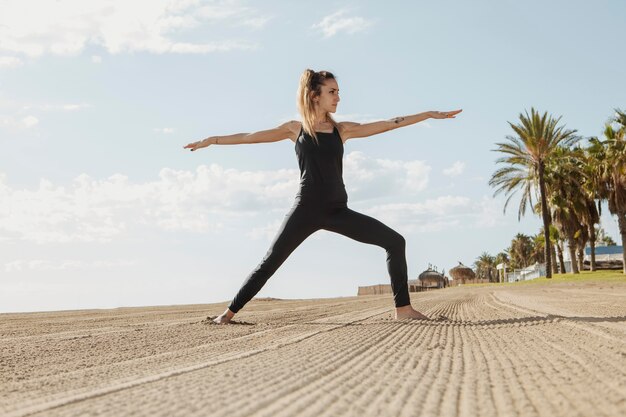 La donna a praticare yoga sulla spiaggia