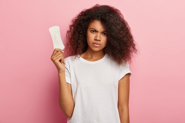 La donna afroamericana cupa si preoccupa dell'igiene personale, tiene l'assorbente