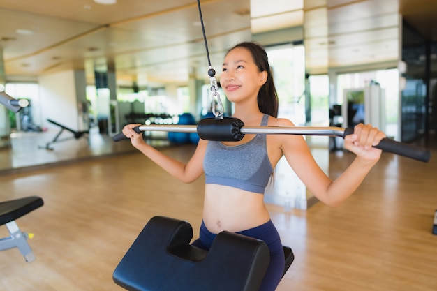 La donna asiatica del ritratto che si esercita e risolve in palestra