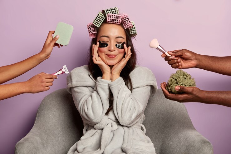 Foto gratuito la donna attraente applica le toppe nere del gel sotto gli occhi, indossa i bigodini