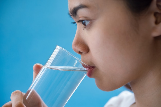 la donna beve acqua dopo aver preso una medicina