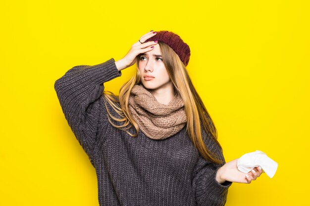 La donna bionda attraente in maglione caldo ha mal di testa e cerca di riscaldarsi