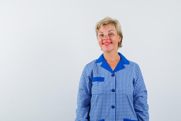 La donna bionda sta sorridendo alla telecamera su sfondo bianco