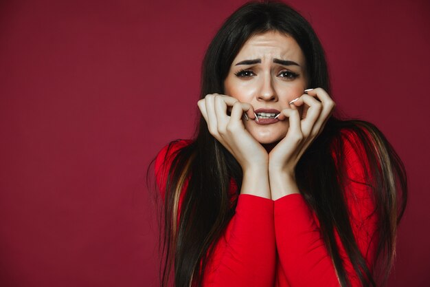 La donna castana ha lo sguardo preoccupato e riposa sulle sue mani