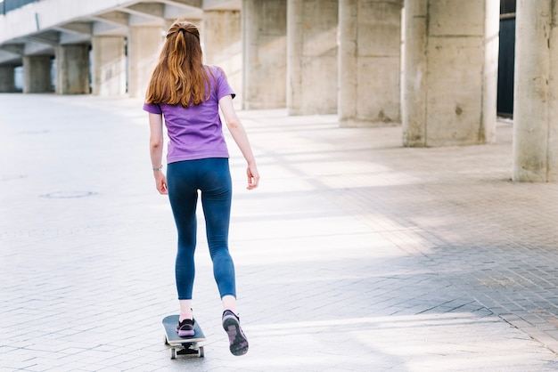 La donna cavalca uno skateboard