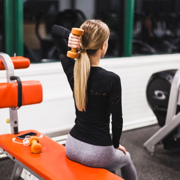 La donna che fa i tricipiti si esercita con il dumbbell