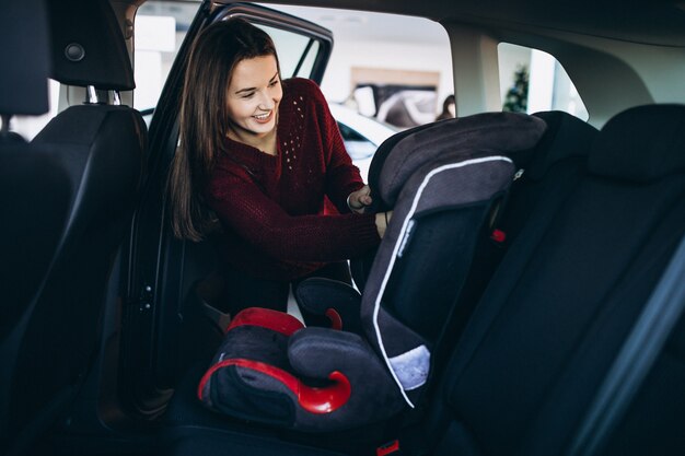 La donna che installa un'automobile di sicurezza si siede in un'automobile