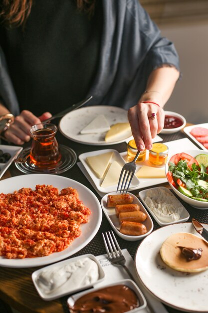 La donna che prende la salsiccia fritta è servito per la prima colazione