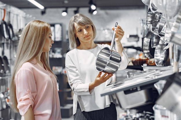 La donna compra i piatti nel negozio