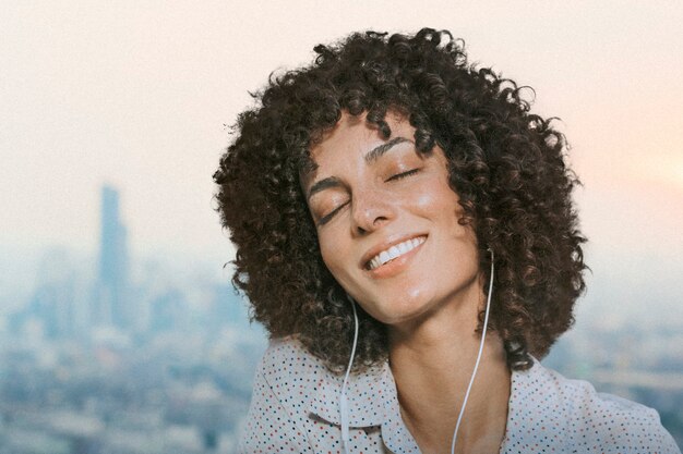 La donna con i capelli ricci che indossa gli auricolari ha remixato i media con vista sulla città