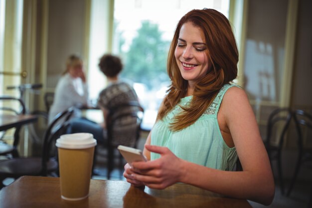 La donna con il cellulare in caffetteria ©