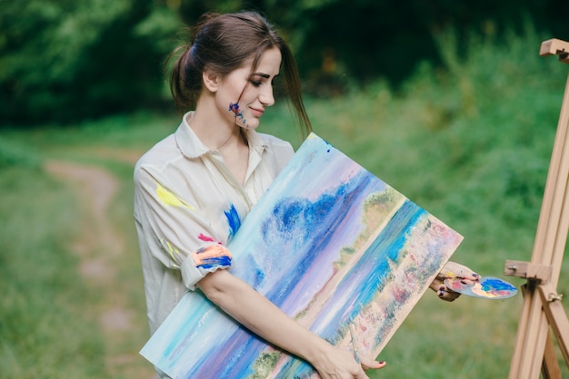La donna con la vernice colorate t-shirt con una foto in mano