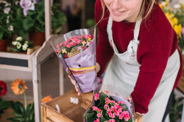 La donna contenta che organizza i fiori consegnati