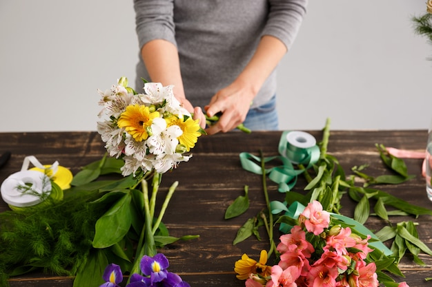 La donna del fiorista fa il mazzo dai fiori variopinti