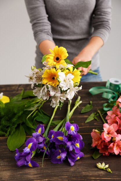 La donna del fiorista fa il mazzo dai fiori variopinti