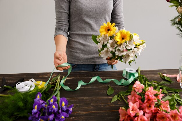 La donna del fiorista fa il mazzo dai fiori variopinti