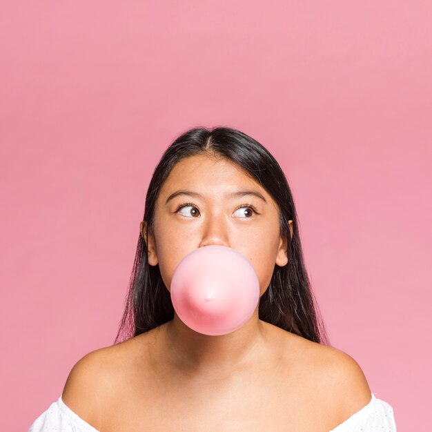 La donna del primo piano gonfia un pallone rosa