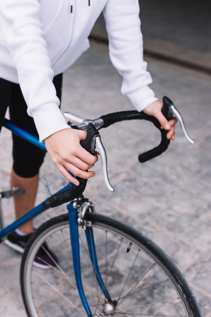 Foto gratuito la donna del raccolto che si tiene per mano sul manubrio della bicicletta
