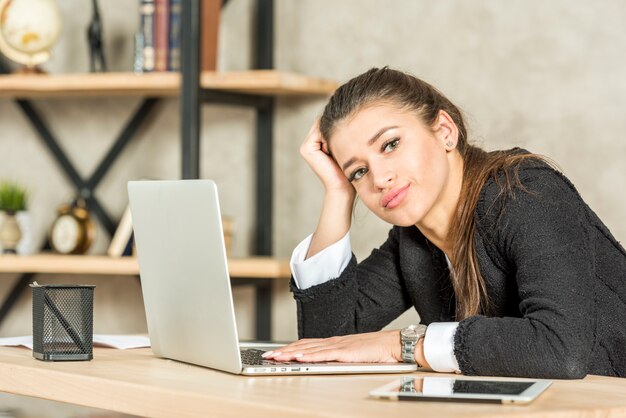 La donna di affari castana ha annoiato nel suo ufficio