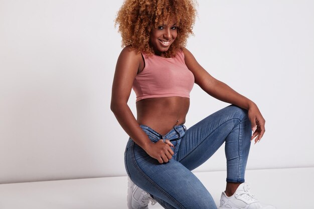 La donna di colore con grandi capelli afro indossa jeans e top