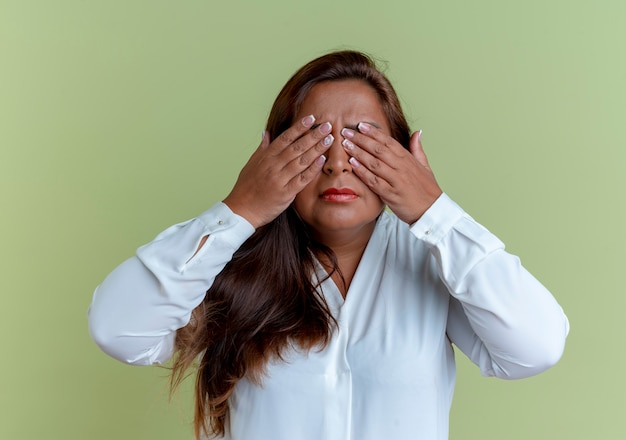 La donna di mezza età caucasica casuale ha coperto gli occhi con le mani